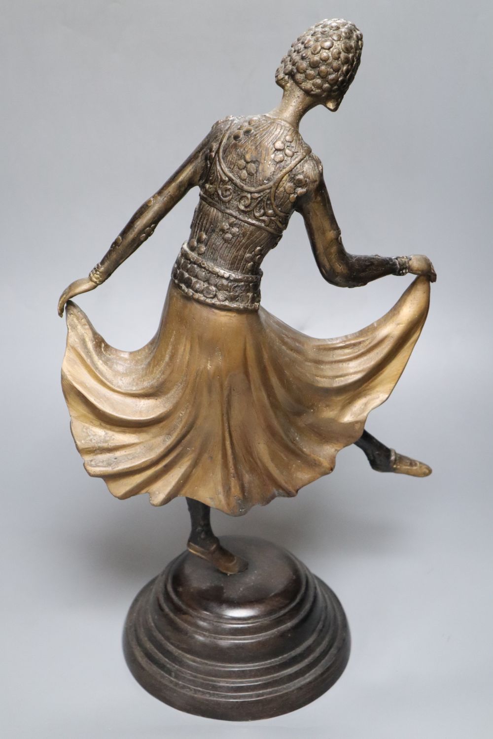 A patinated metal model of a 1930s dancer, on stepped circular base, 48cm